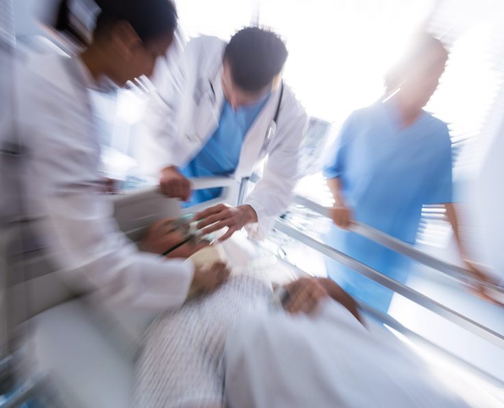 Team of doctors putting oxygen mask on a male senior patient face in the hospital